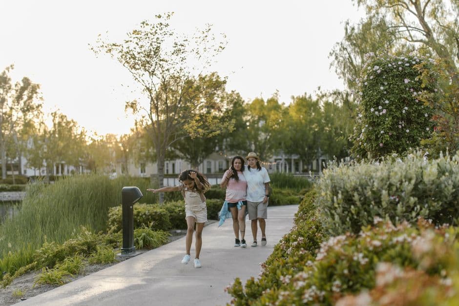 Parents and their child walking through a leafy school grounds on an open-day tour in Melbourne.