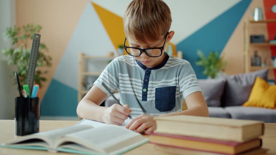 A primary-school child working at a tidy desk with a planner and books, calm and focused, with no phone or clutter in sight.